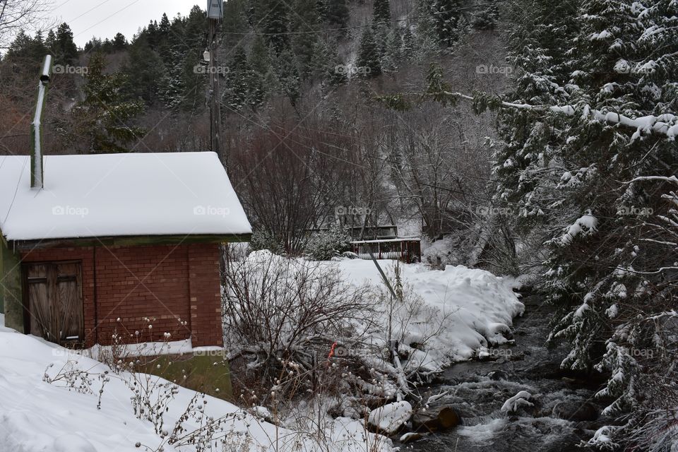 A winter landscape with a brick shed. 