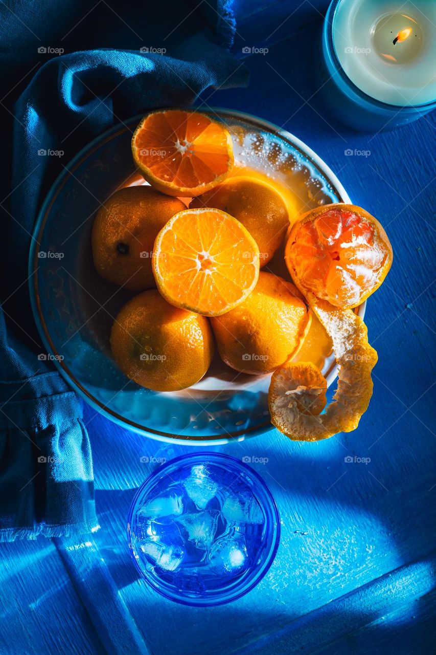 Fresh and juicy tangerines on blue plates.