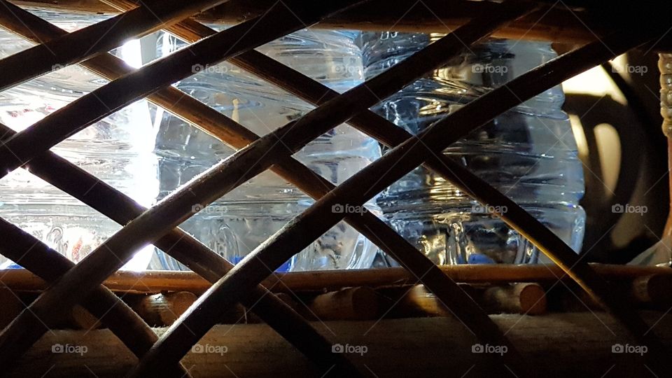 messing around with some bottles of water mineral in a rattan shelf..