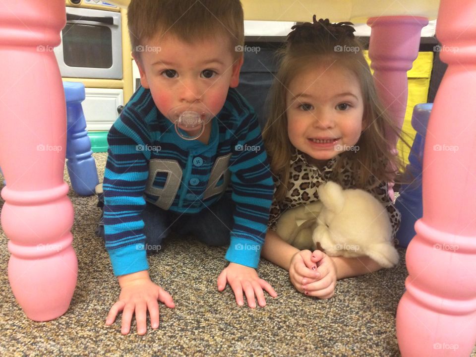 Toddler Siblings under a table 