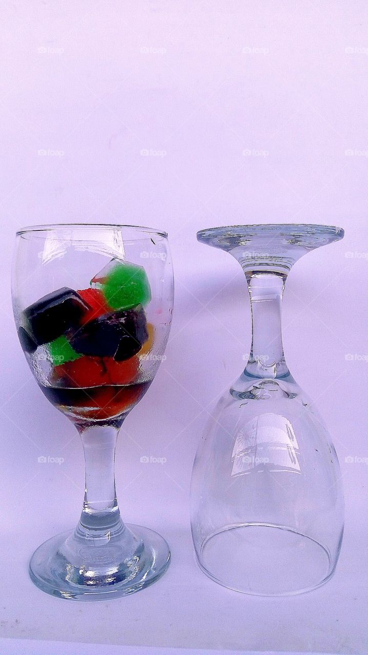 Glass glasses with colorful ice cubes