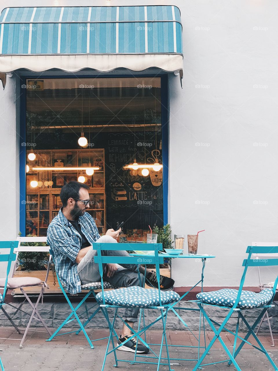 Bearded man using mobile in a street cafe 