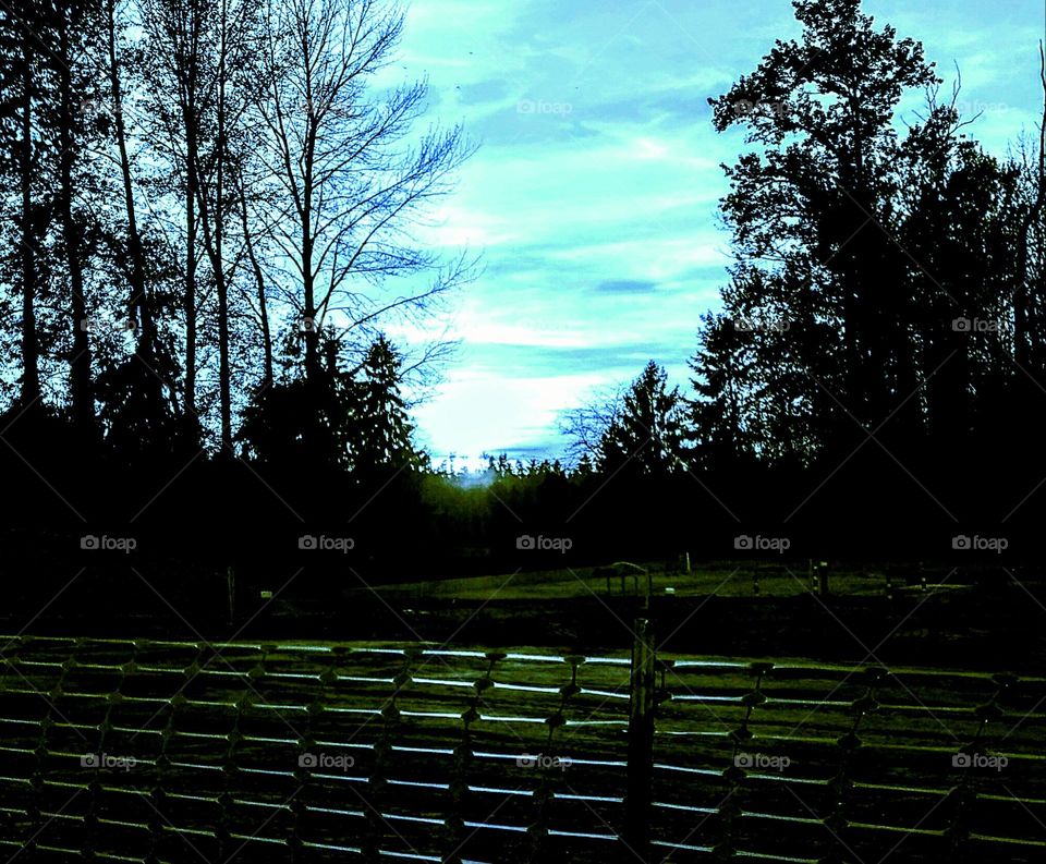 Late afternoon, minutes before the sun sets, fluffy clouds dot the blue sky at this construction site.