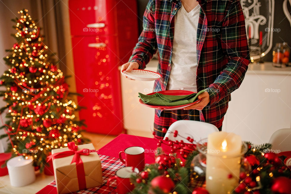 man sets a beautiful decorated winter table for a festive dinner.  Merry Christmas and Happy New Year.