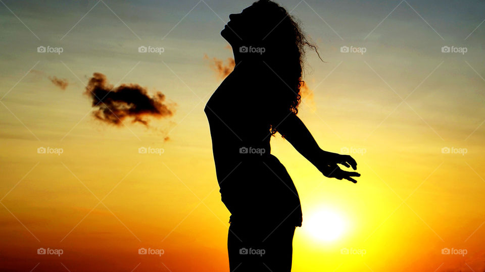 Silhouette of woman against dramatic sky