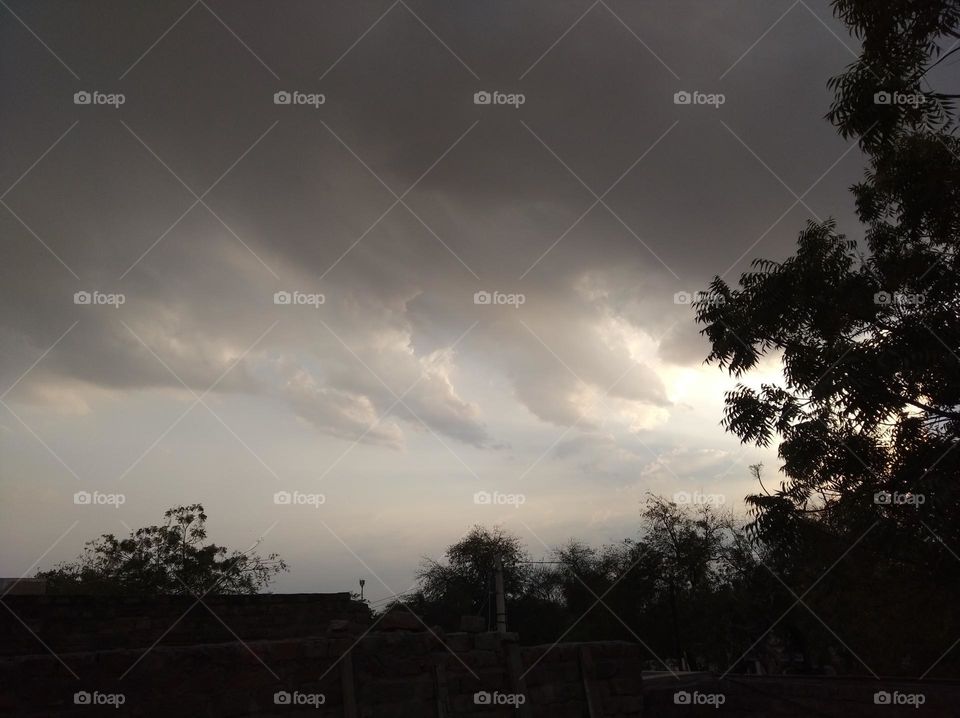 Sun set scene whites cloud scattered dark tree clouds whites shining slightly dark,just to sun set