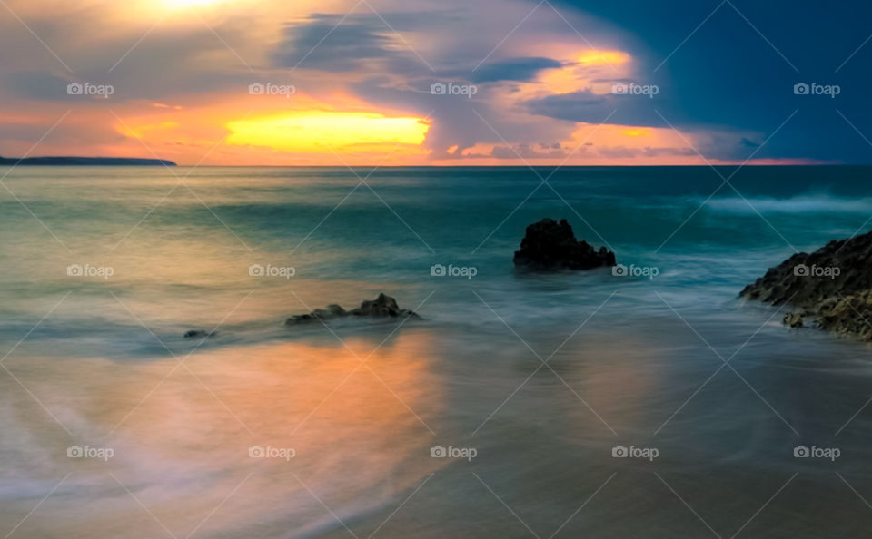 As the sunset over the Atlantic Ocean, a storm begins to roll in, leaving the sky a blur of vibrant colours