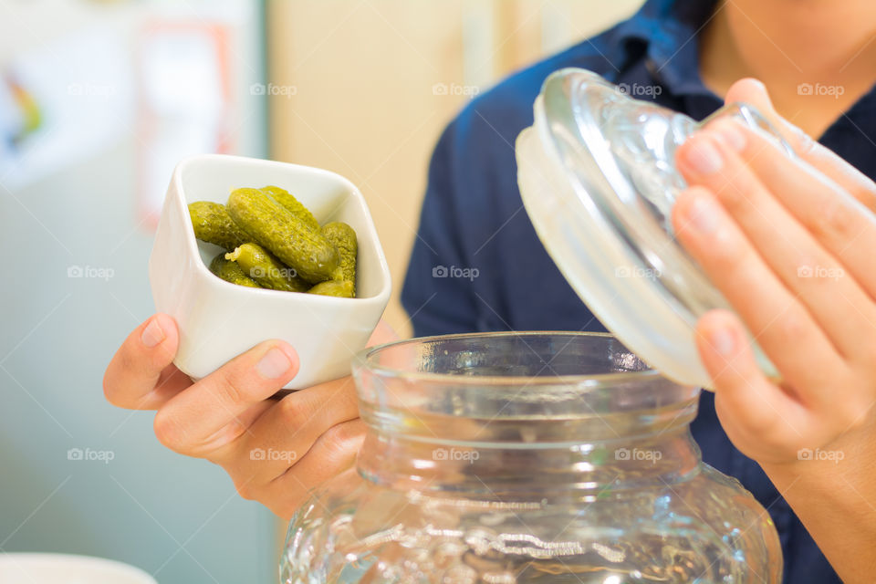 Hands holding a recipient full of pickles to cook a very good meal 