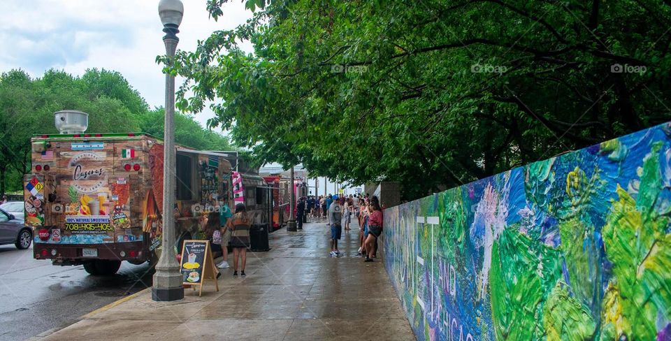 Food trucks in the street in Chicago on a rainy day with Monet paintings on the wall