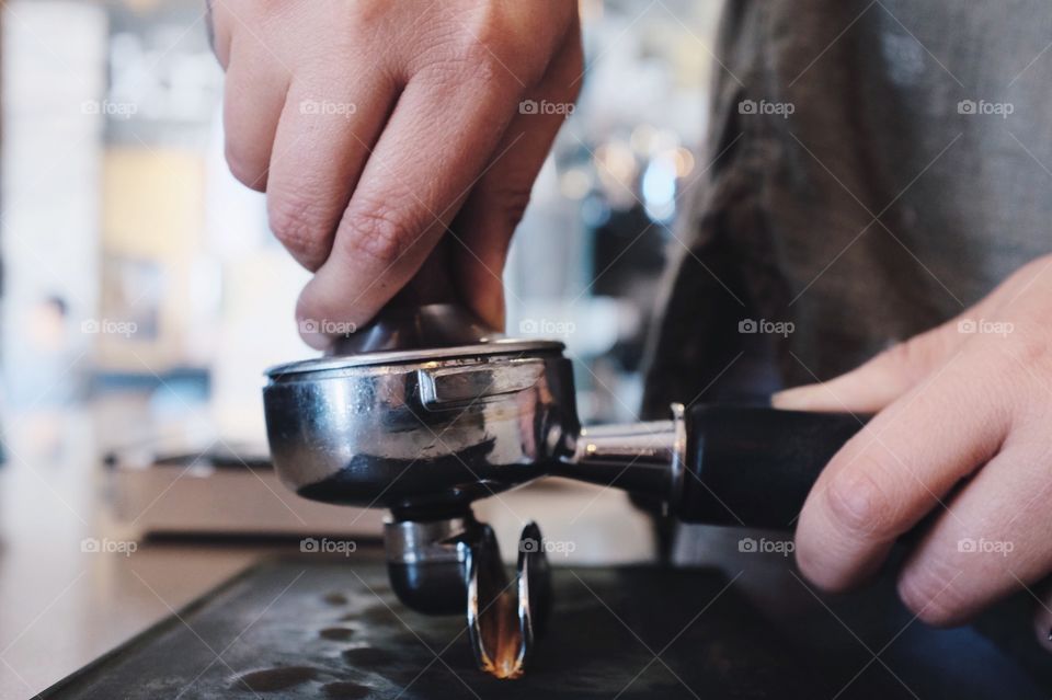 Barista tamping grounds in portafilter