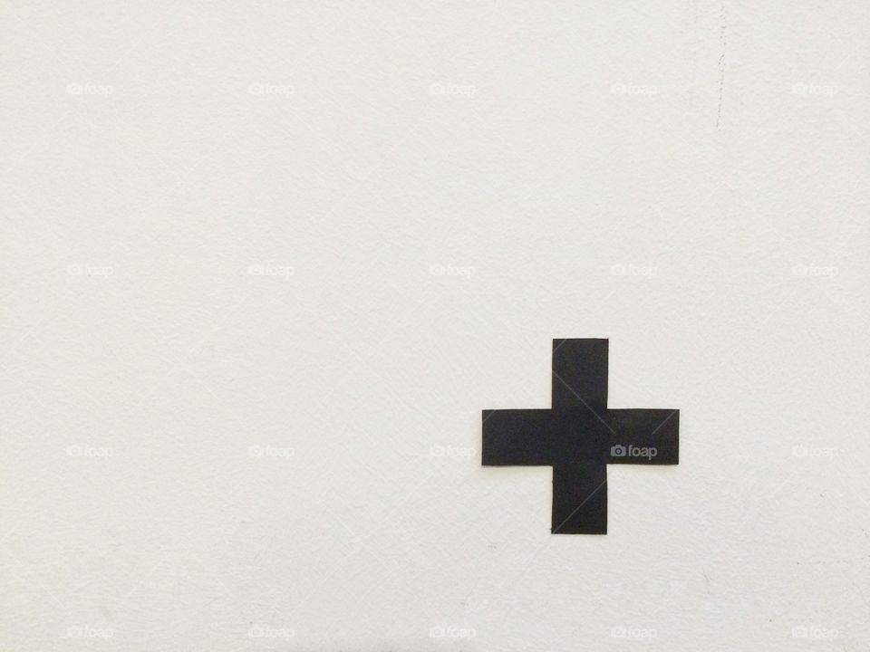 Black cross on a white wall