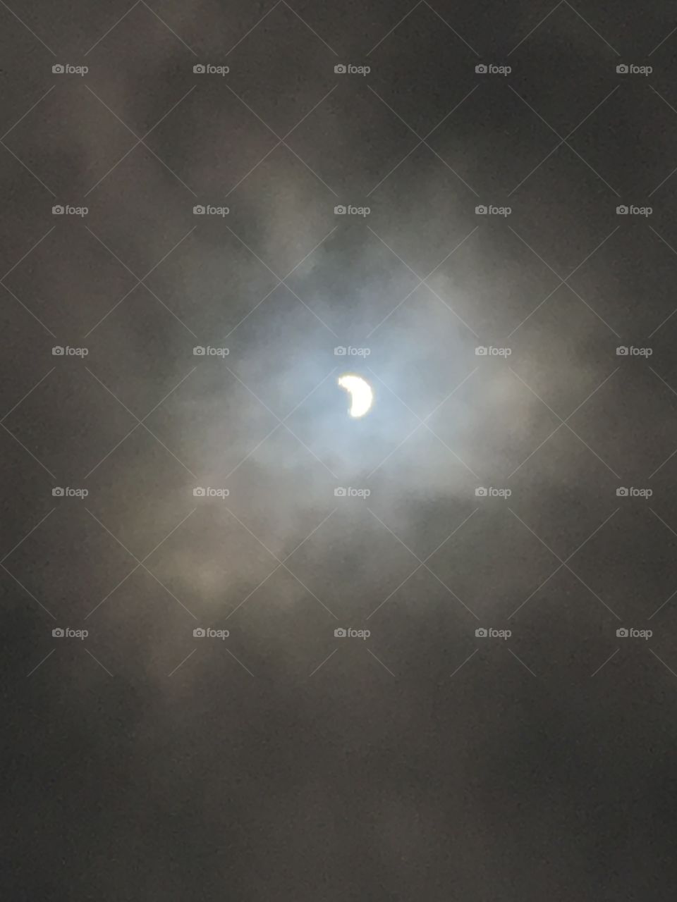 Solar eclipse in a cloudy sky