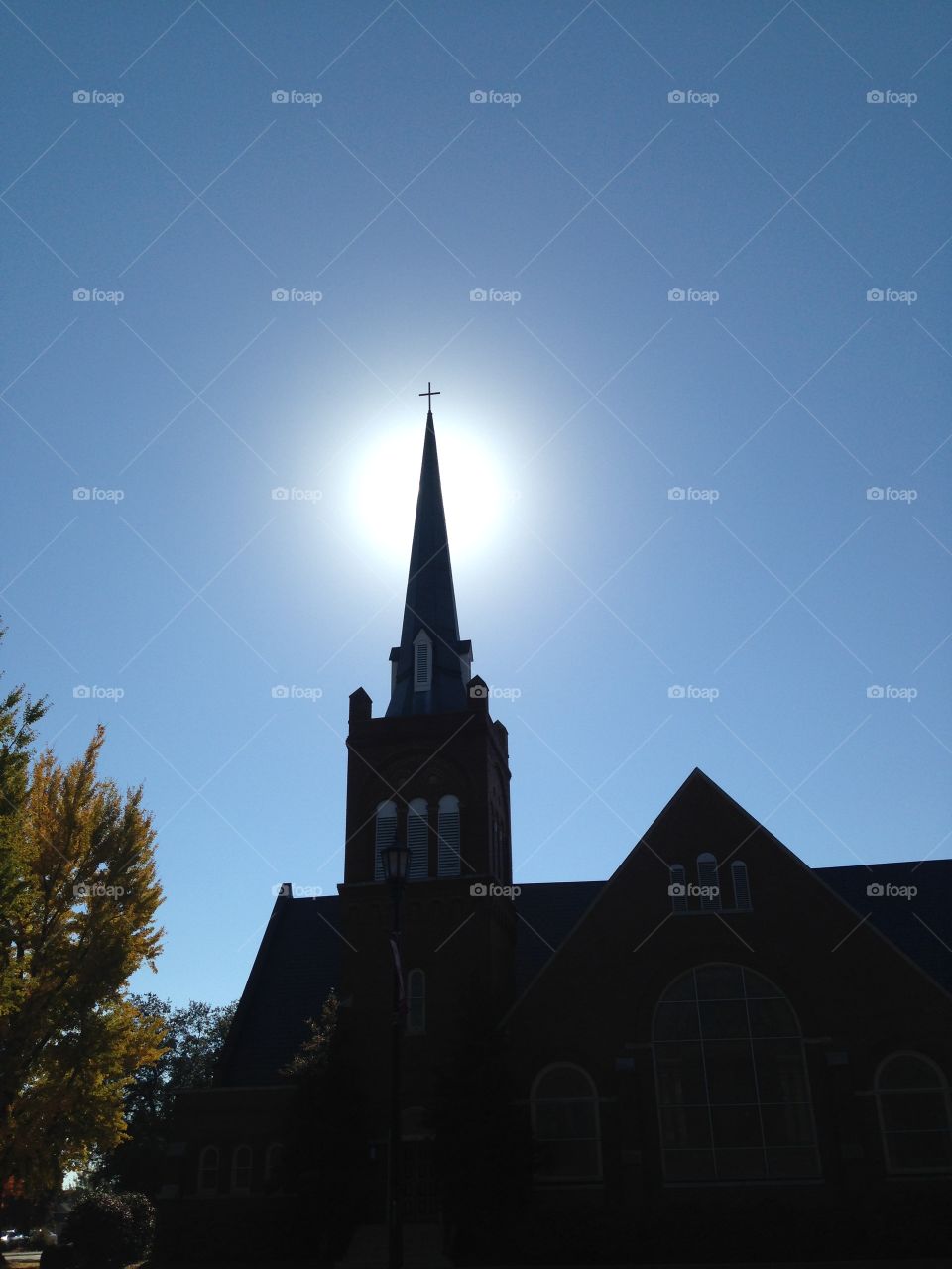 Sun rays behind a church steeple 