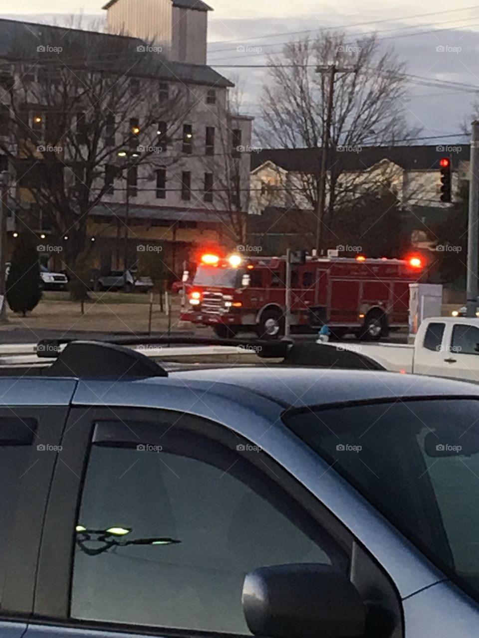 Big red fire truck going on a call with it’s  red lights flashing-horn blowing. 
