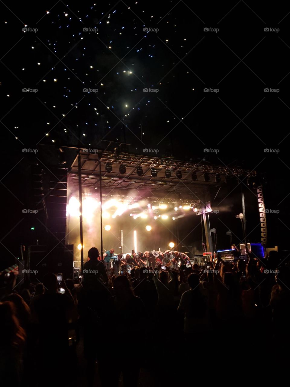 A magical moment of awe and joy for the young child on his fathers shoulders when fireworks explode as the concert comes to an end.