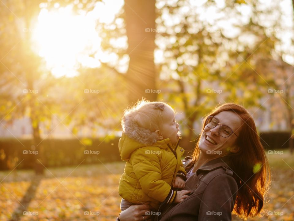 Mother and daughter in a park laughing  Happy family time