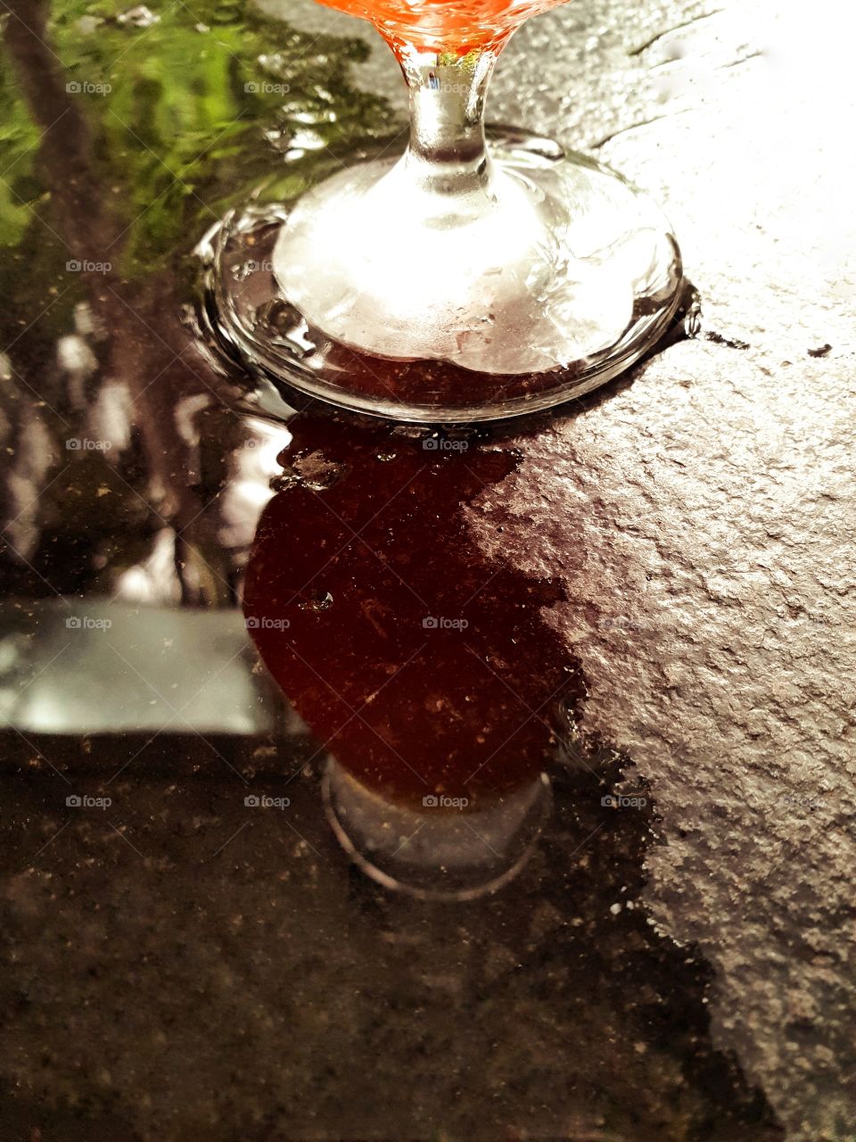 Glass of Iced Tea Reflected in Wet Surface