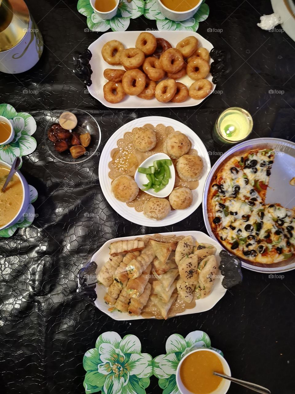 A meal consisting of pizza pies donut fingers stuffed with cheese