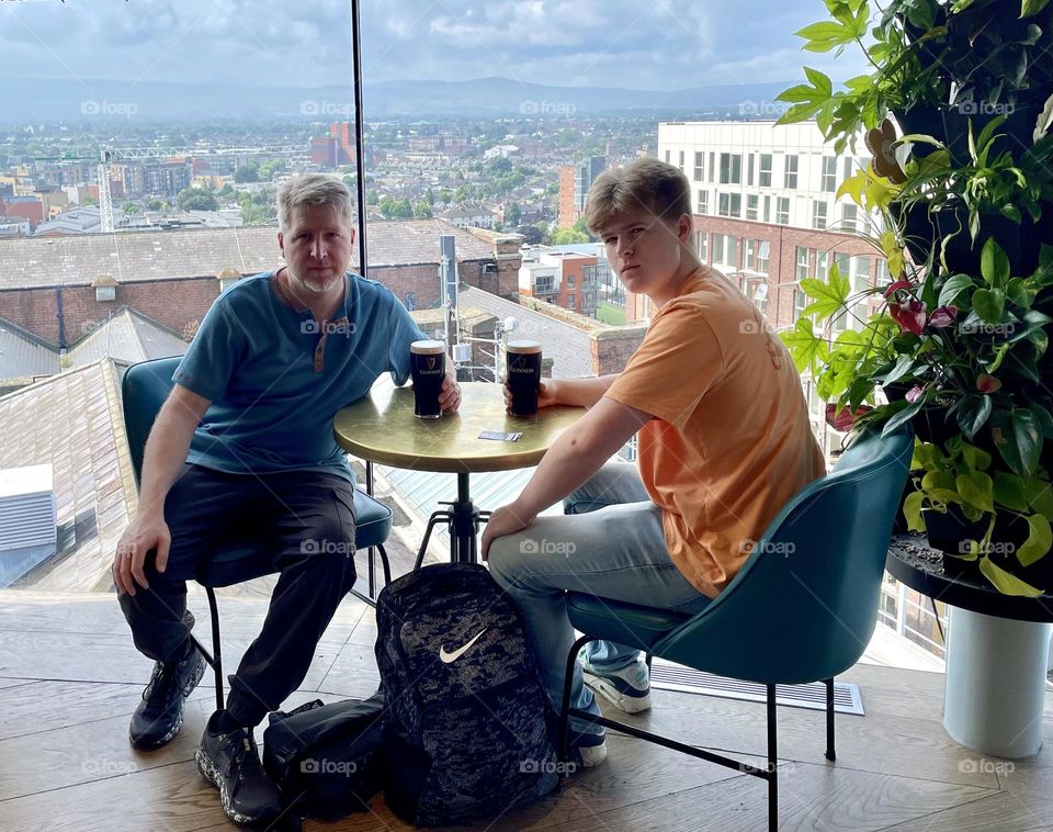 Father and son enjoy a couple pints of Guinness in the Gravity Bar at the top of the Guinness Storehouse in Dublin, Ireland.