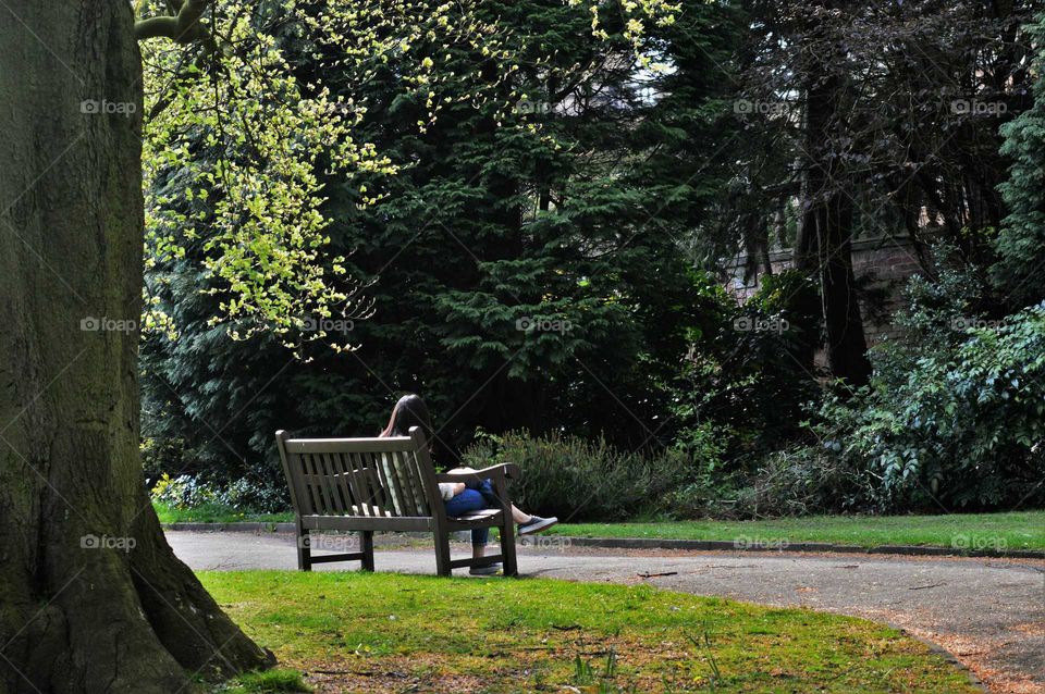 Girl sitting alone on a park bench
