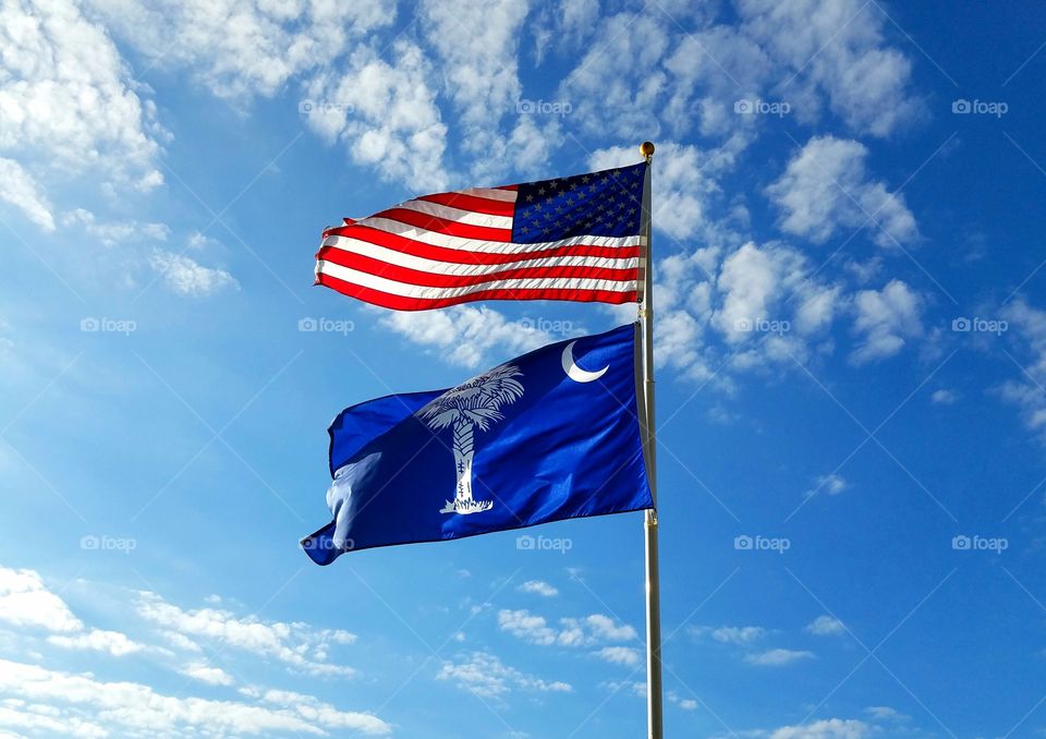 American and South Carolina flags with sky background