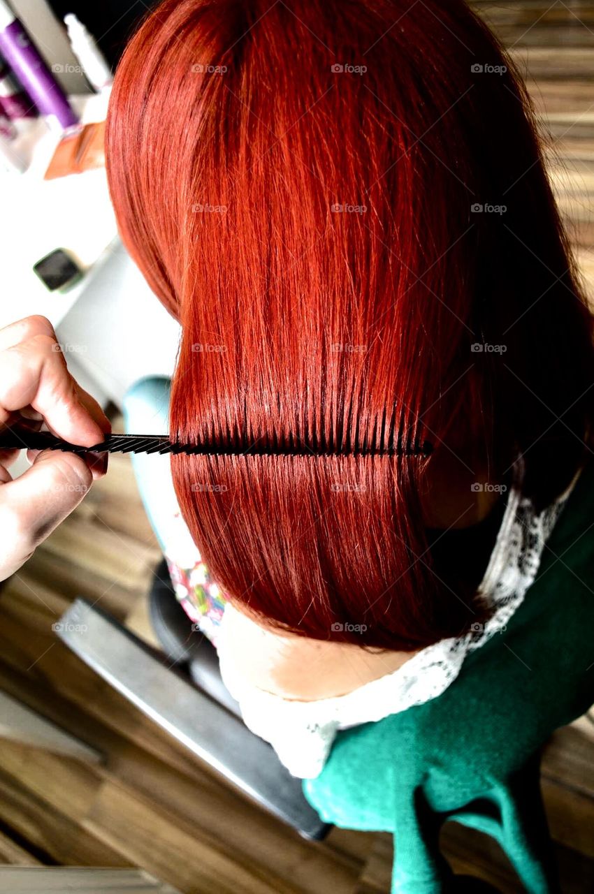 Red hair Strand of hair on a big comb on a beautiful redhead