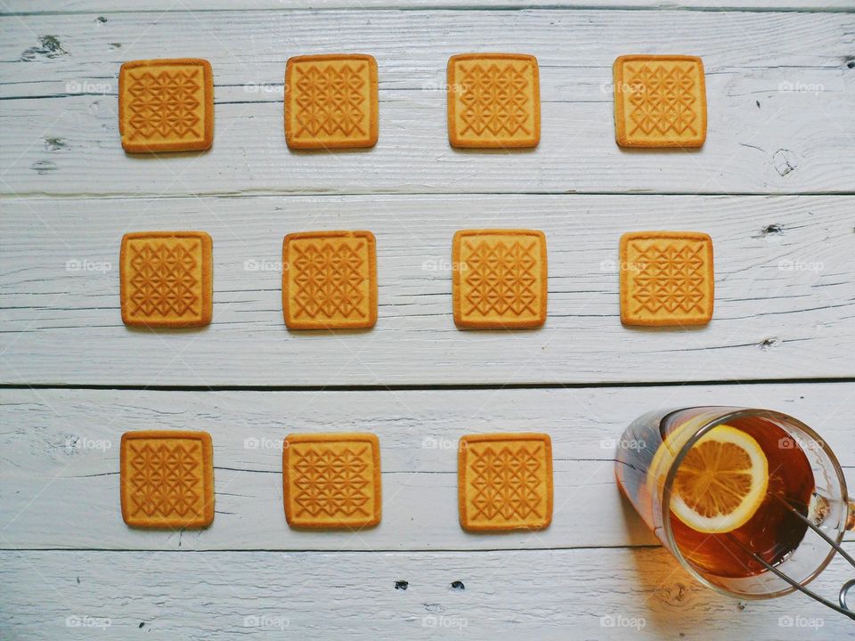 cookies and a cup of tea with lemon on a white background