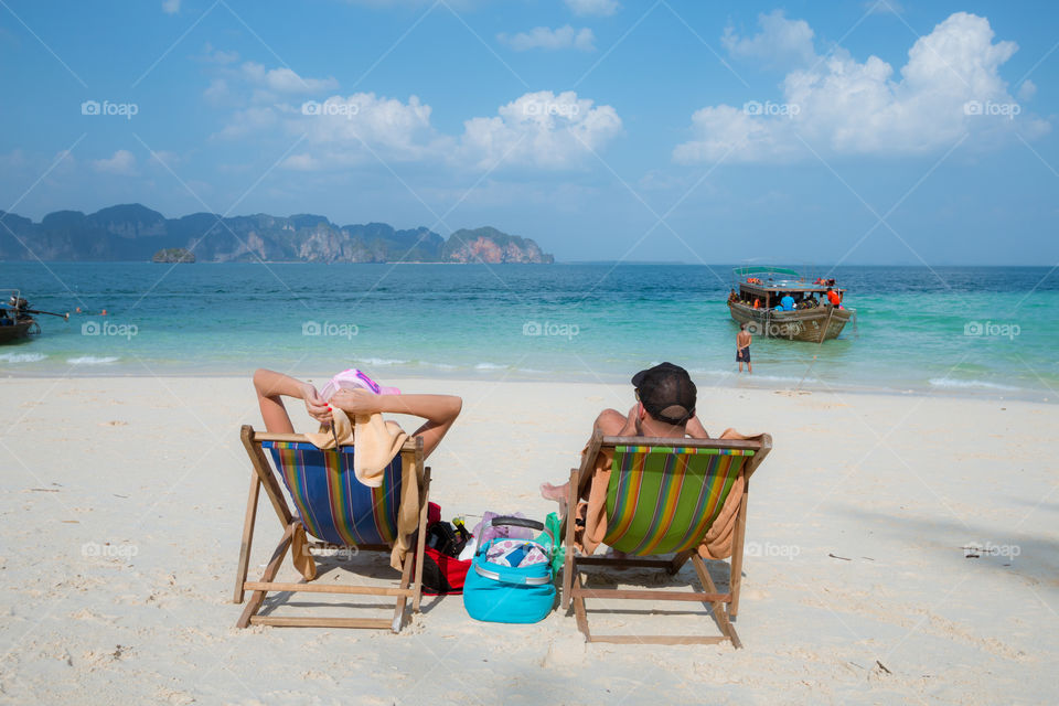 Tourist lover sitting on the beach chair 