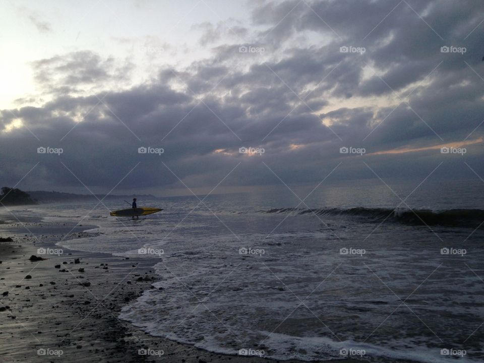 Surfer heading to sea