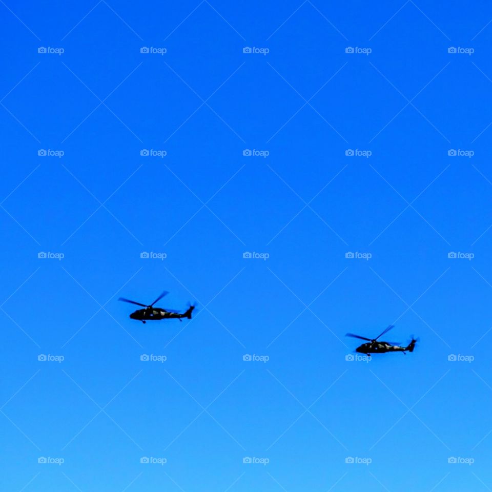 Military Helicopters fly over ocean