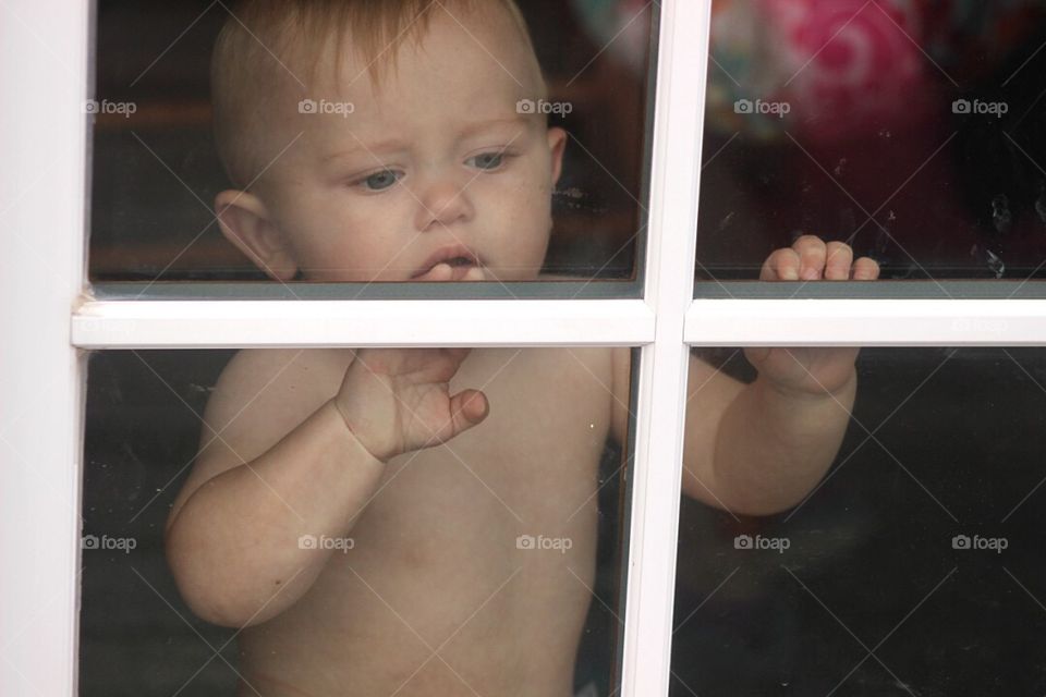 Cute boy looking through window