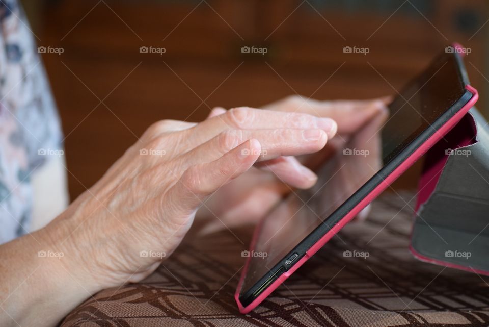 A Grandmother keeps in touch with family using modern technology.