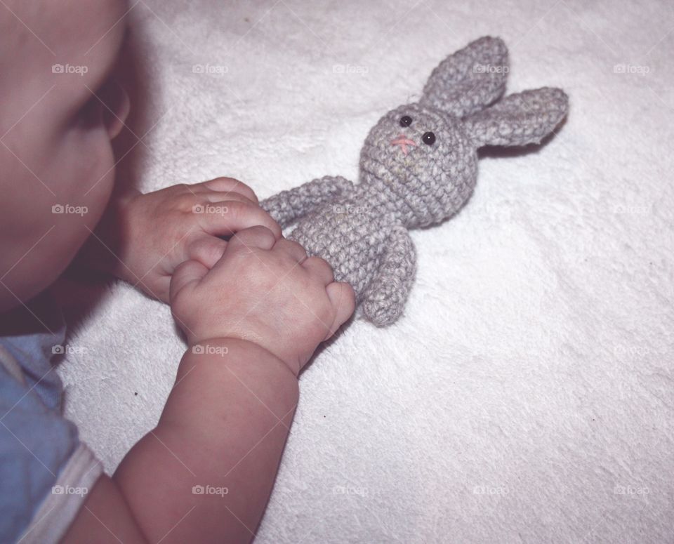knitted bunny in little children's hands, baby toy