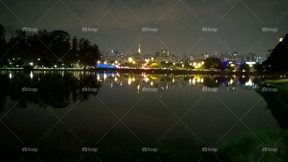 Ibirapuera lake during night in São Paulo city. Urban lights on the background