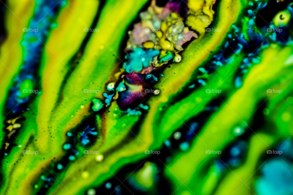 The ink to refill the printer cartridge was spilled onto the white washbasin and the paints blended into abstract drips and patterns.