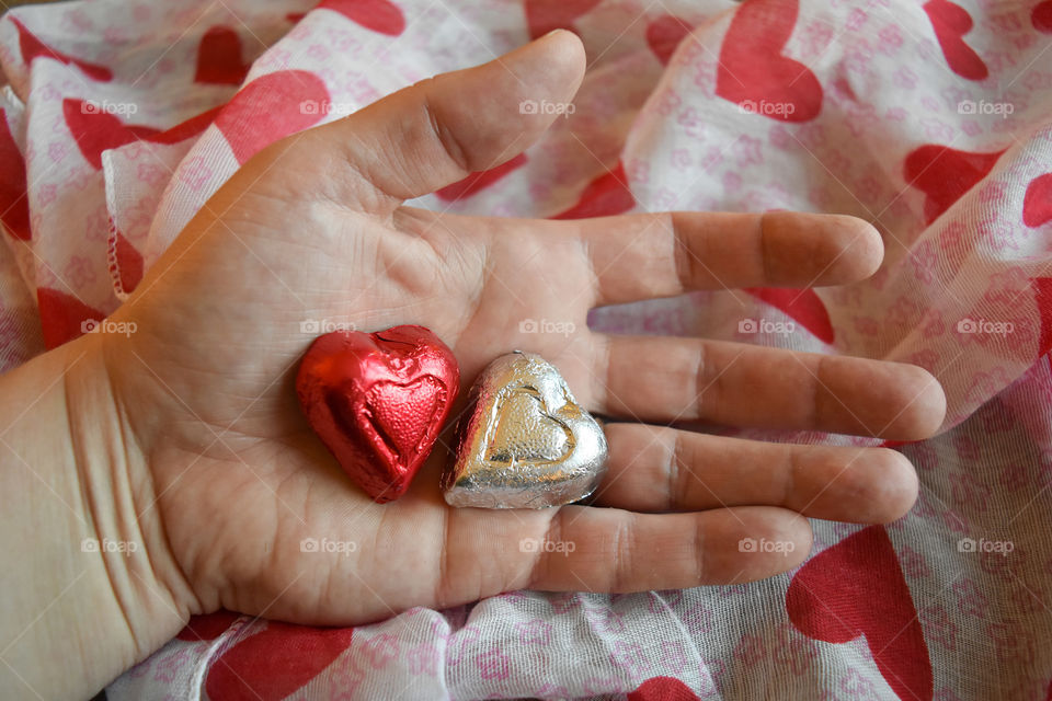 Hand holding heart shaped candy