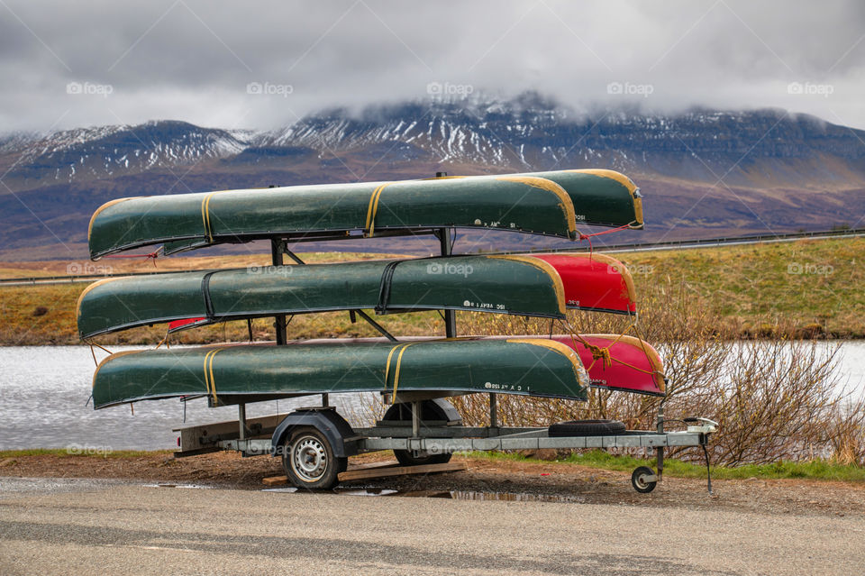 Stack of canoes near lake