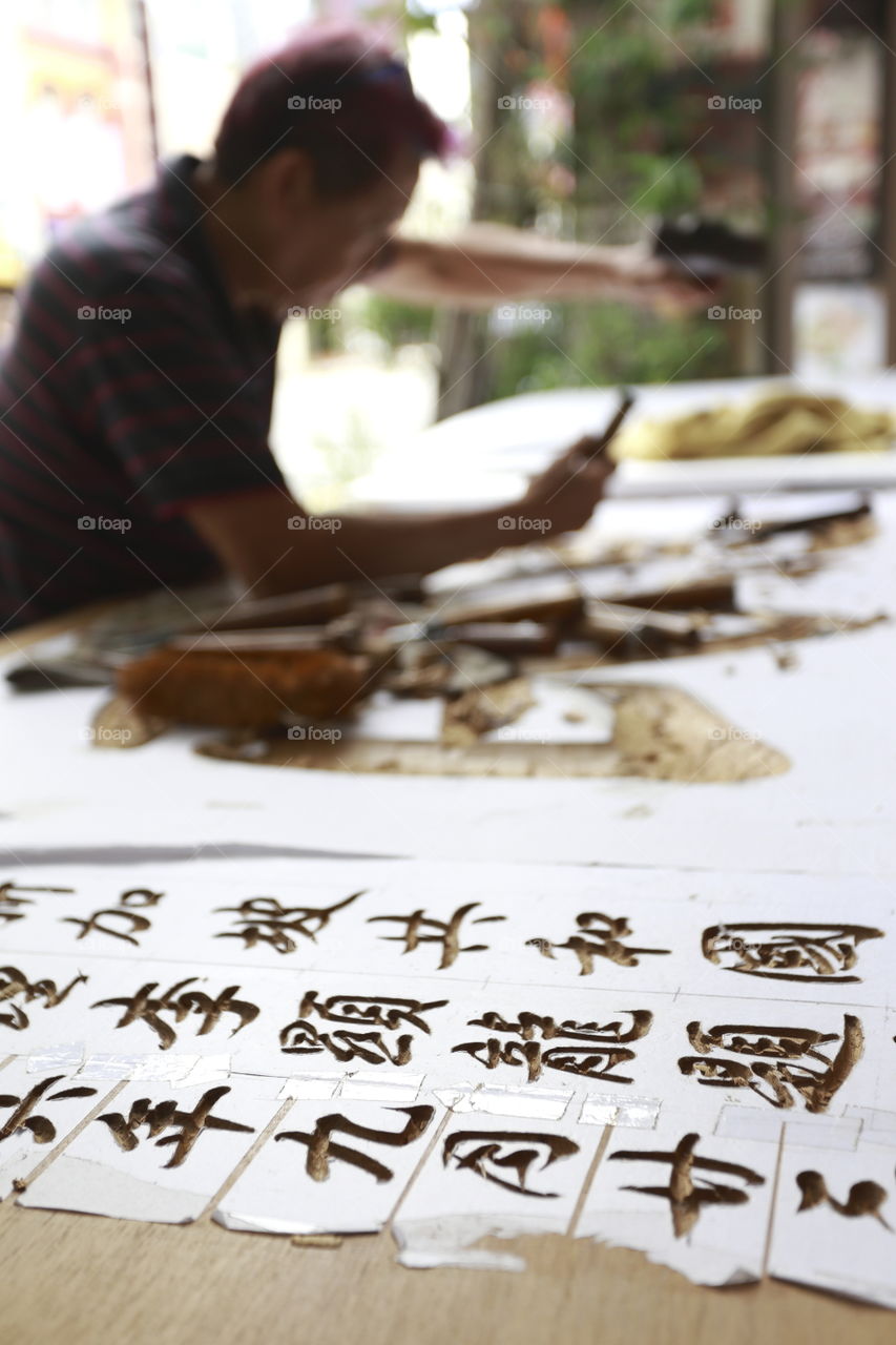 close up of Chinese letter carving on wood by an artist street shop in Singapore