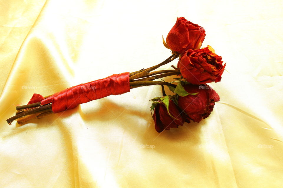 bouquet of red roses on Golden textile material