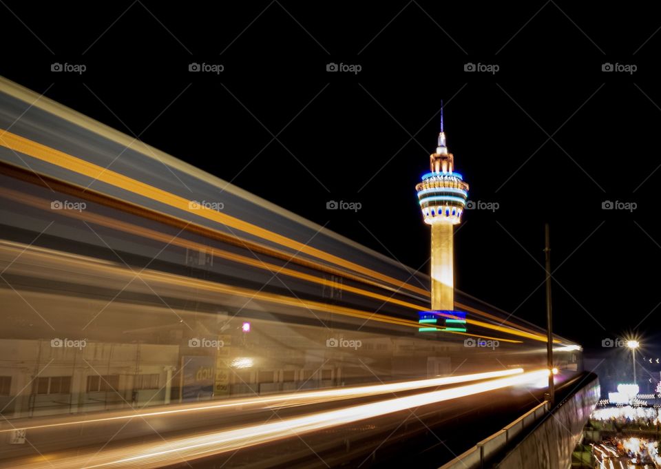 Light of Electric train BTS when reach to station on beautiful background of City tower of Samut Prakan province,Thailand