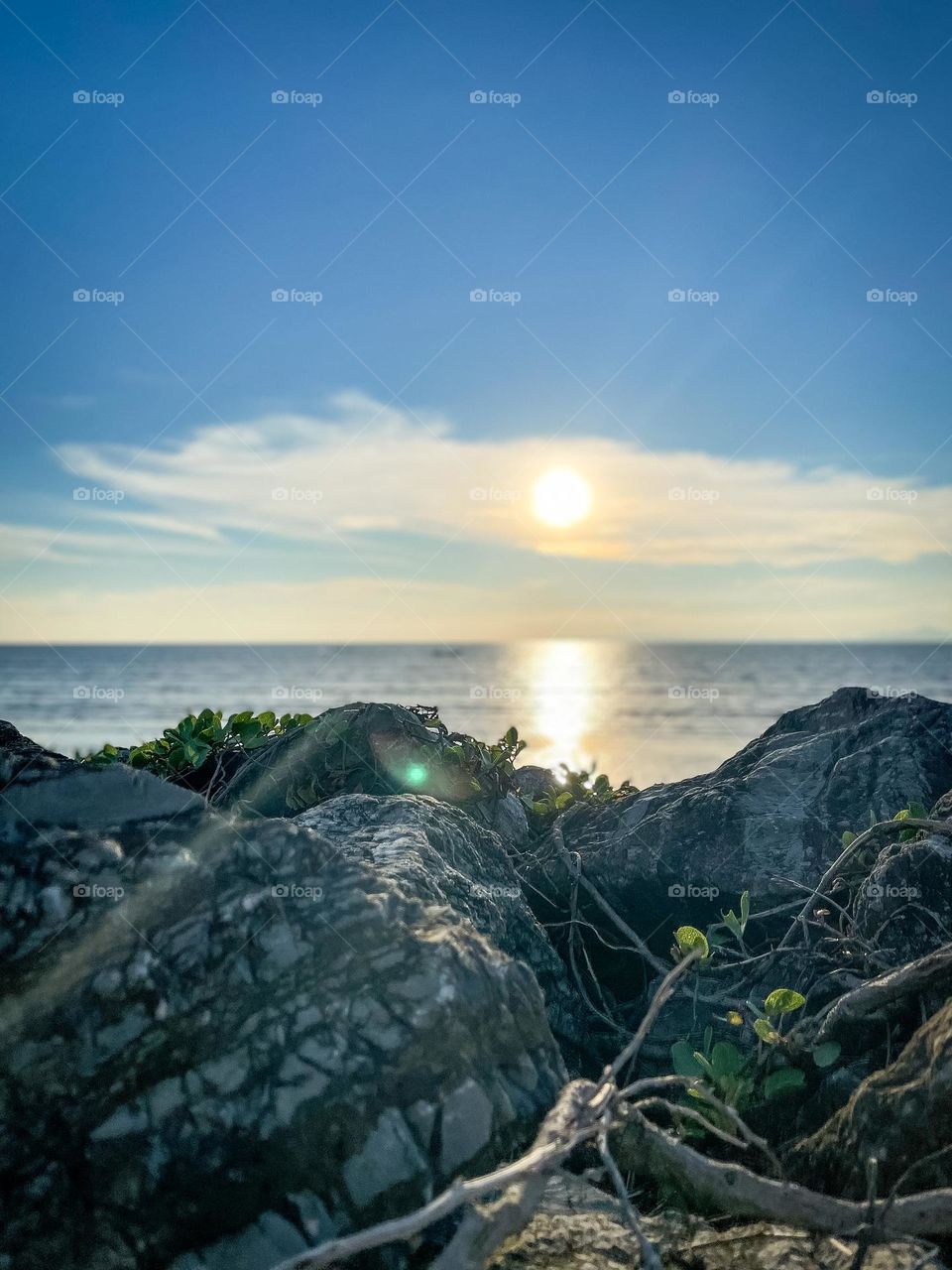 Sunset at the rocky beach with blue sky