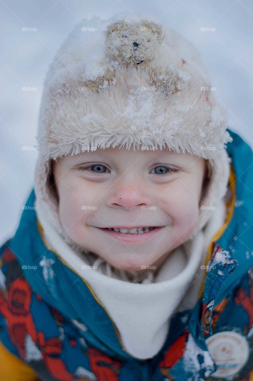 Toddler boy beeing happy about winter acivities.
