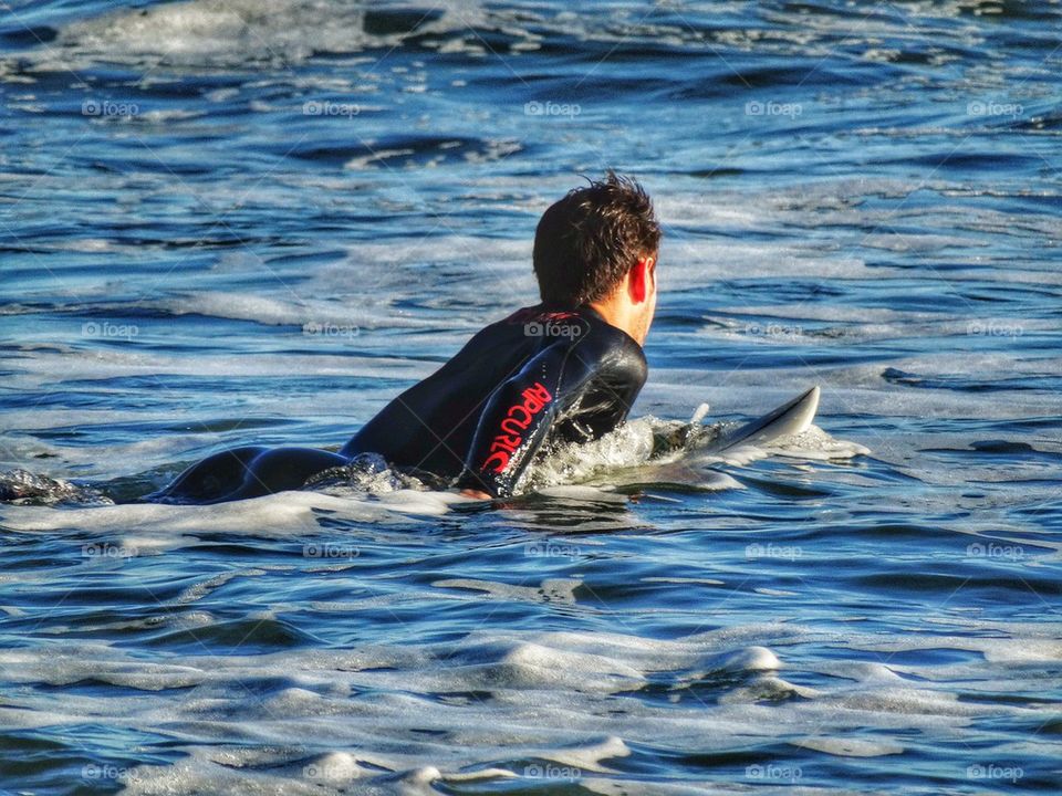 Athletic Surfer Paddling Into The Waves. California Surfer
