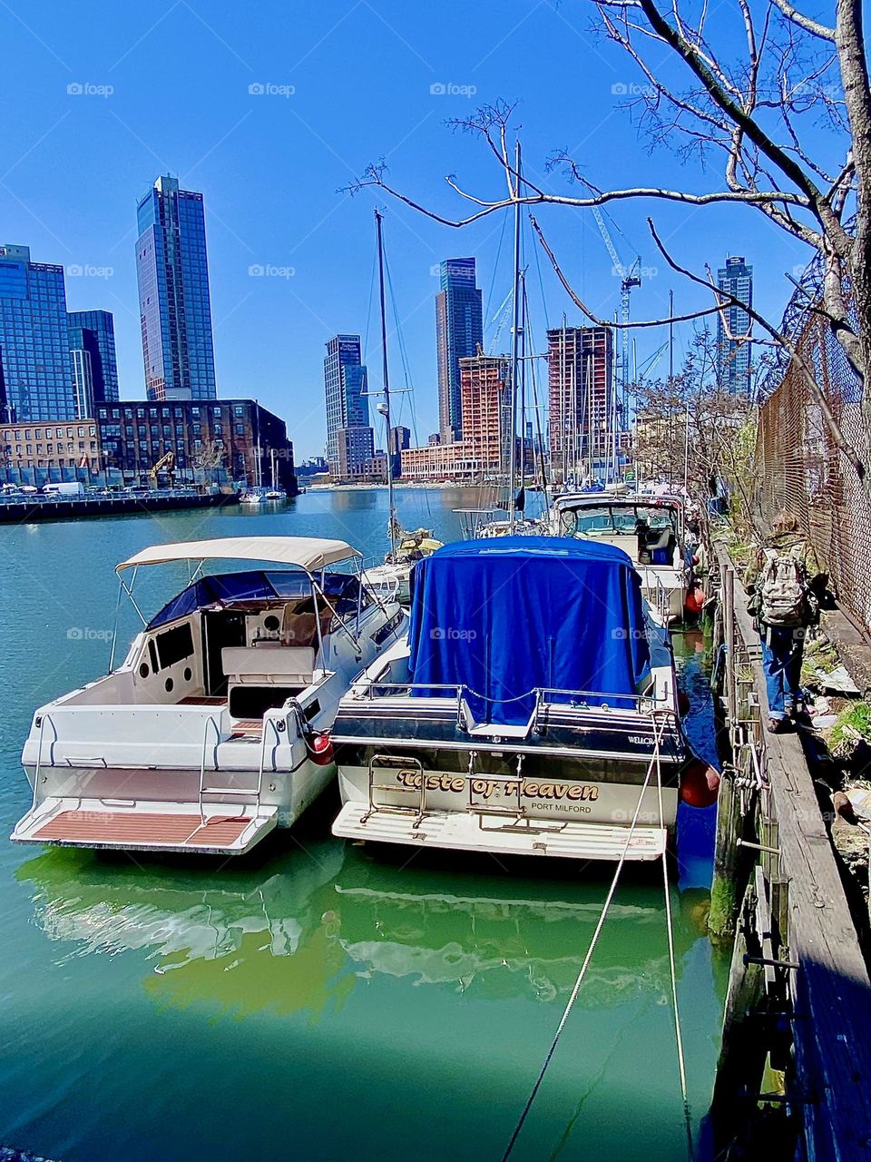 The ocean’s color at “Newtown Creek” in LIC, Queens is somewhere between turquoise blue and green today and it’s reflecting the boats that are tied to the shore perfectly. 2023. Hypnotic Productions