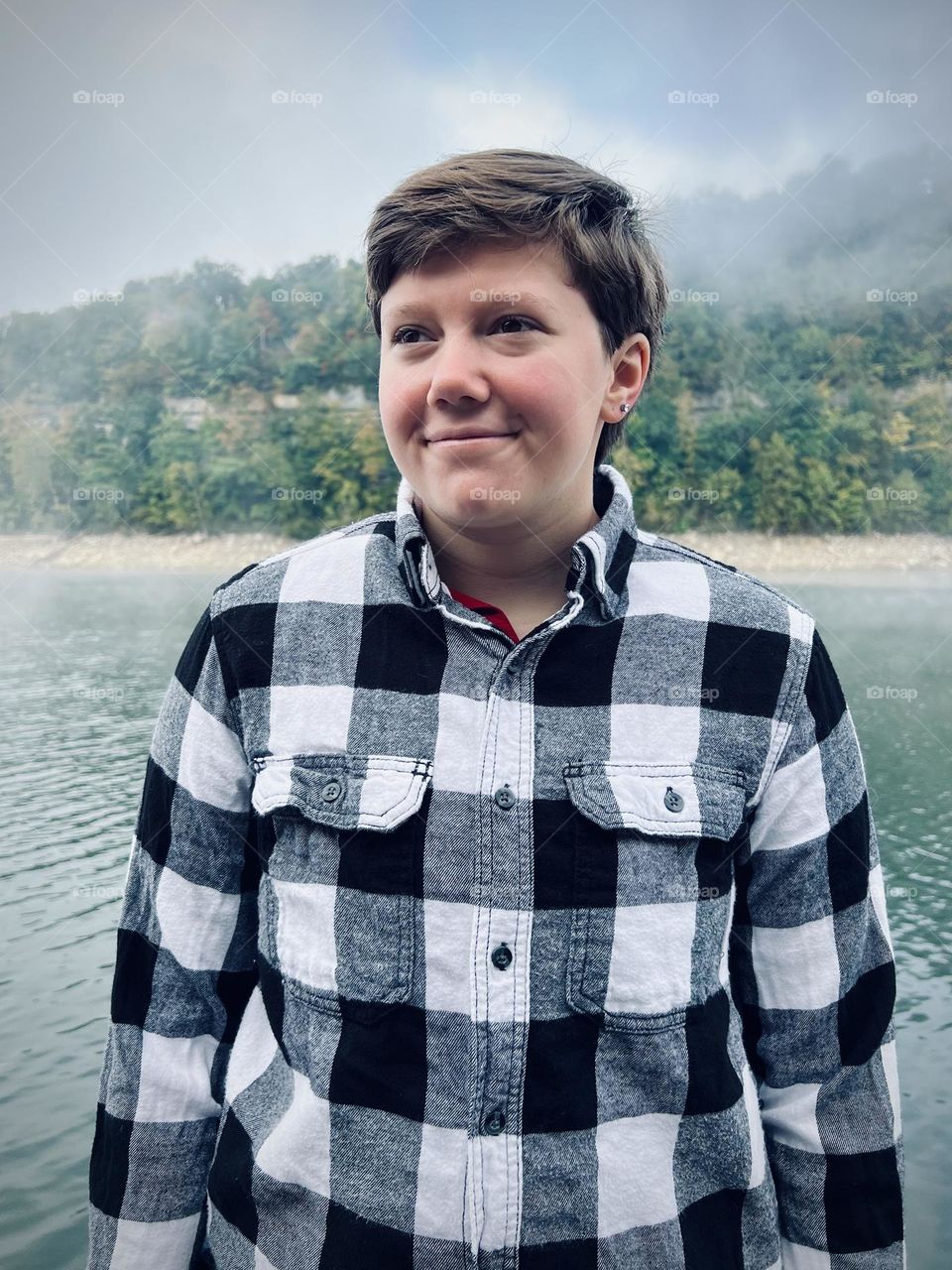 A young man enjoying a peaceful foggy morning on the dock