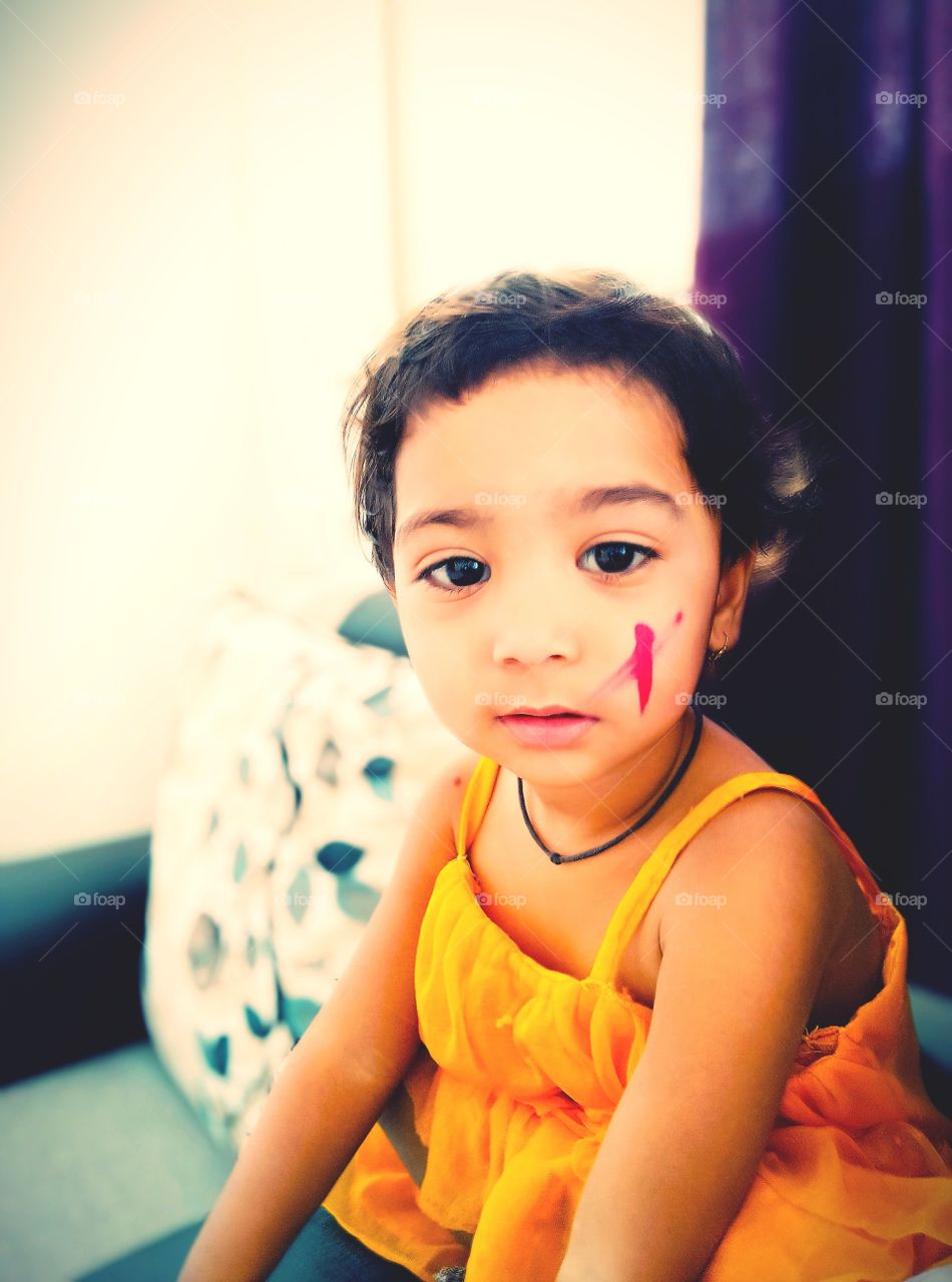 Baby girl enjoying Holi festival with colours