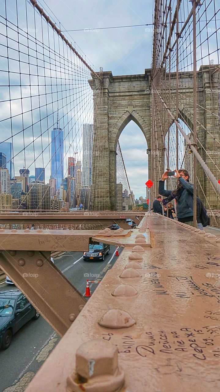 A photographer taking shots of the Brooklyn Bridge in NY. 