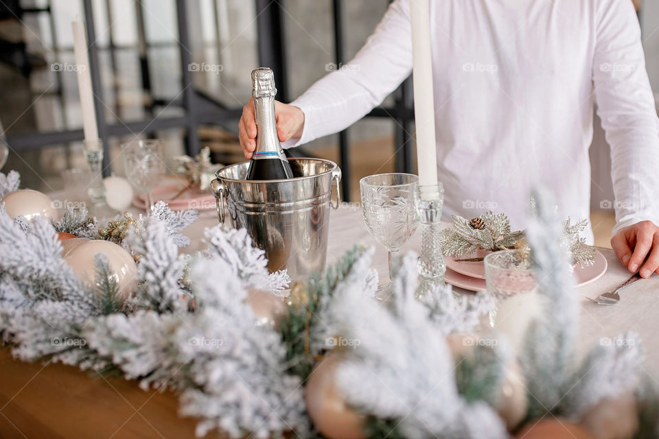 man sets a beautiful decorated winter table for a festive dinner.  Merry Christmas and Happy New Year.