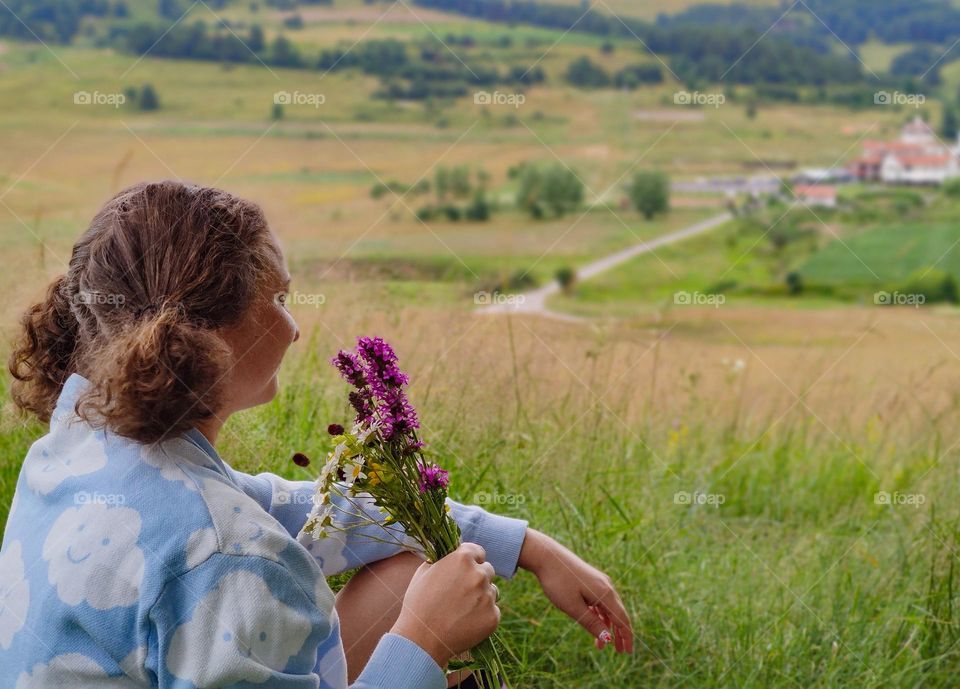 Enjoying the divine countryside with wild flowers in hand