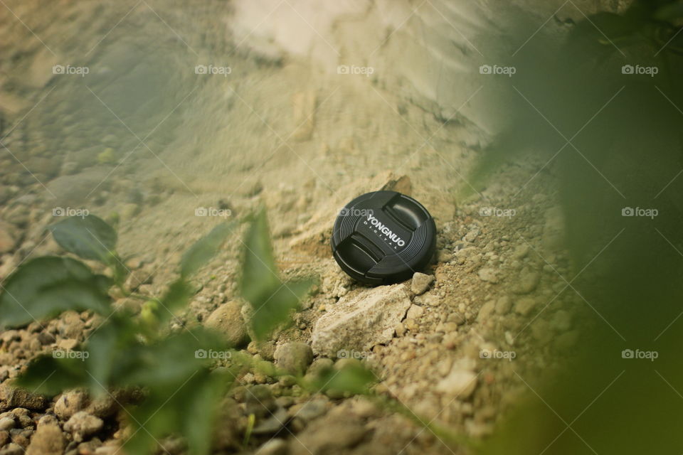 camera lens cap on the sand